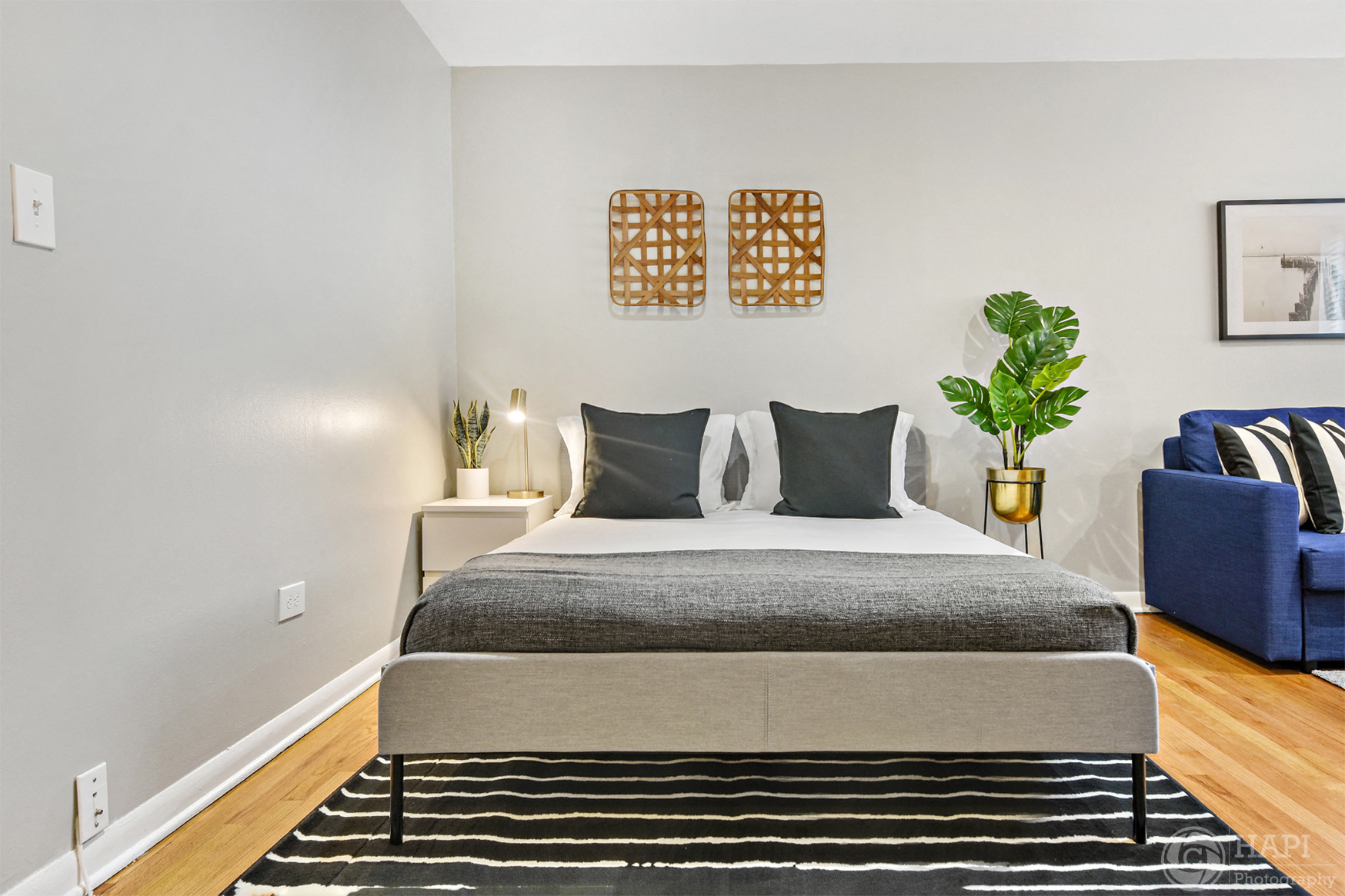 a bedroom with a bed and a blue chair and a rug