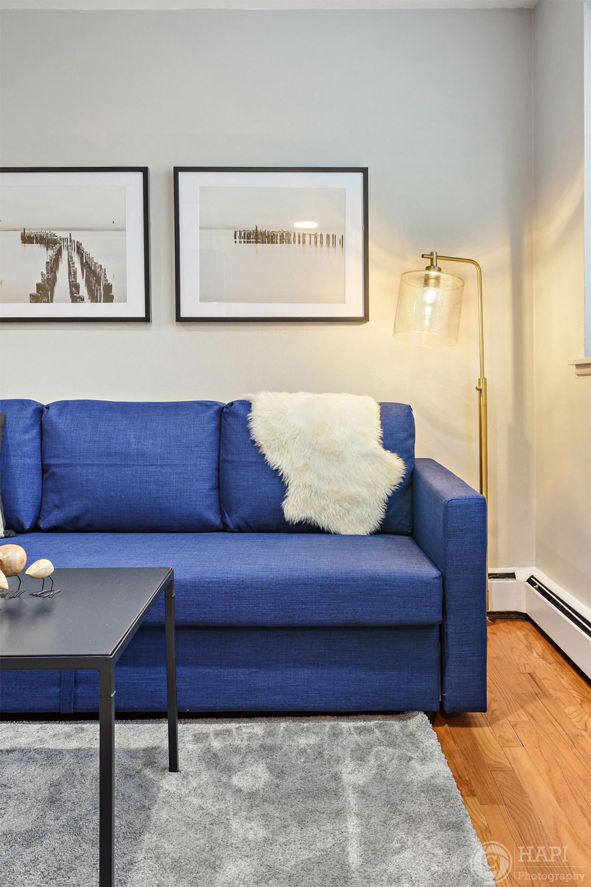 a living room with a blue couch and a lamp
