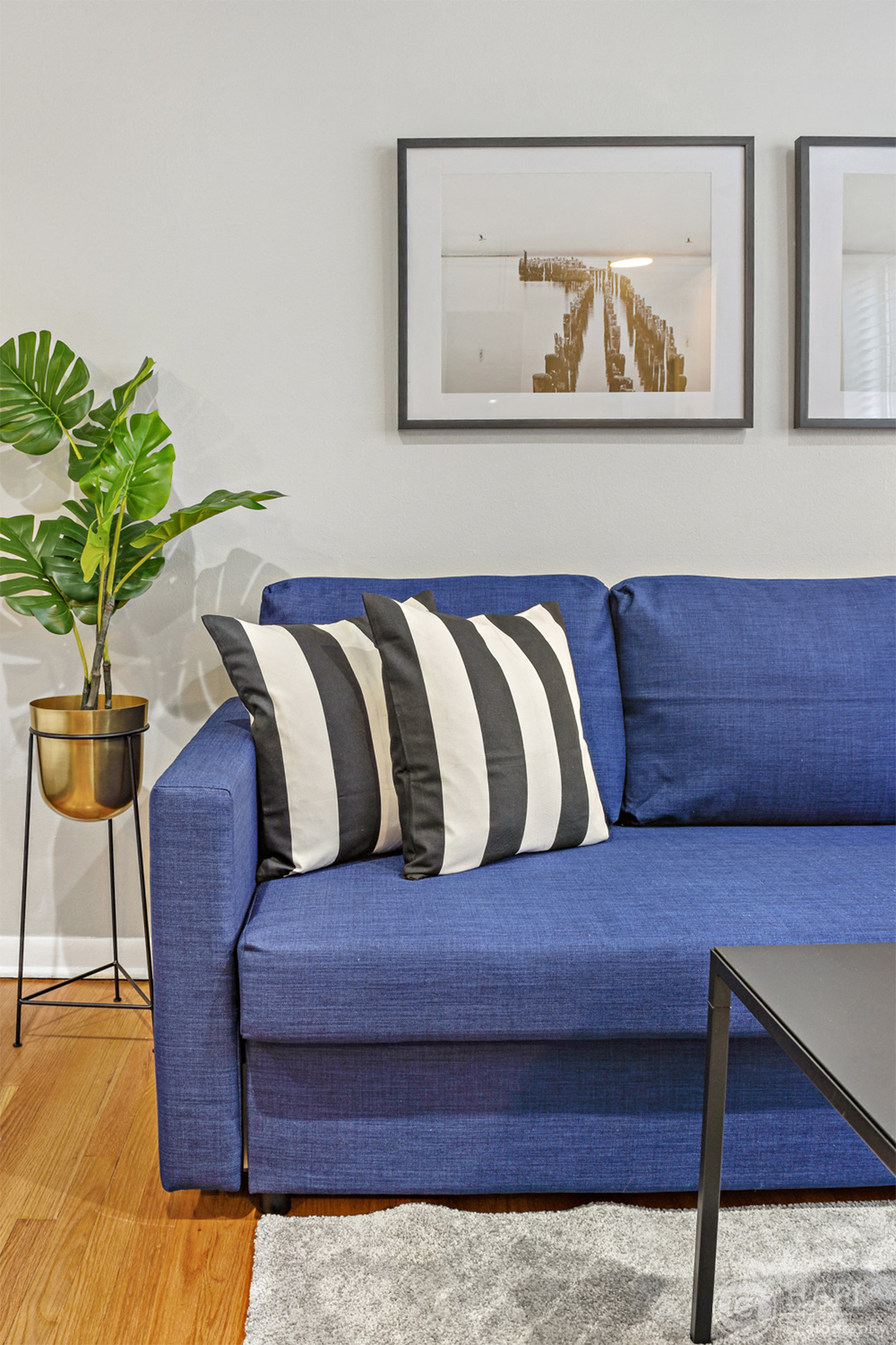 a blue couch with black and white pillows in a living room