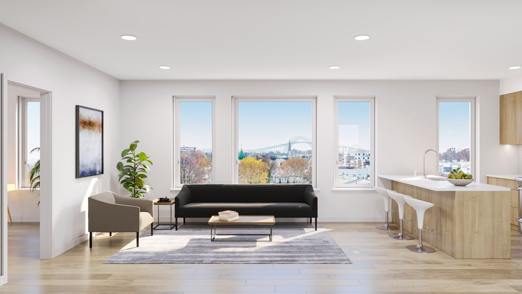 A modern living room with a black sofa and a wooden counter.