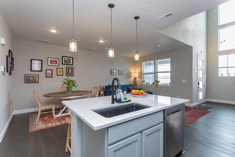 A kitchen with a white counter top and a sink.