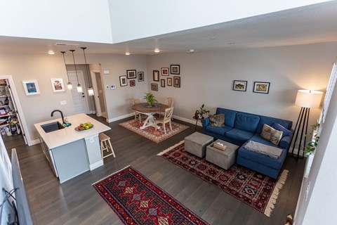 A living room with a blue couch and a rug.