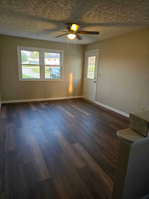 a living room with a wood floor and a ceiling fan
