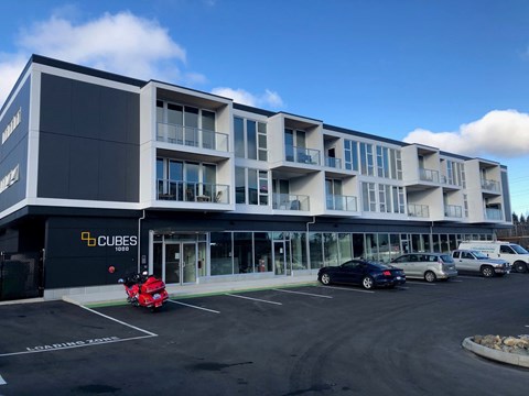 A parking lot in front of a building with the sign "CUBES".