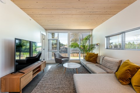 A modern living room with a flat screen TV and a large window.