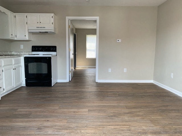 A kitchen with a black oven and white cabinets.