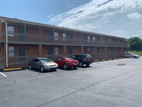 A parking lot with cars and a building in the background.