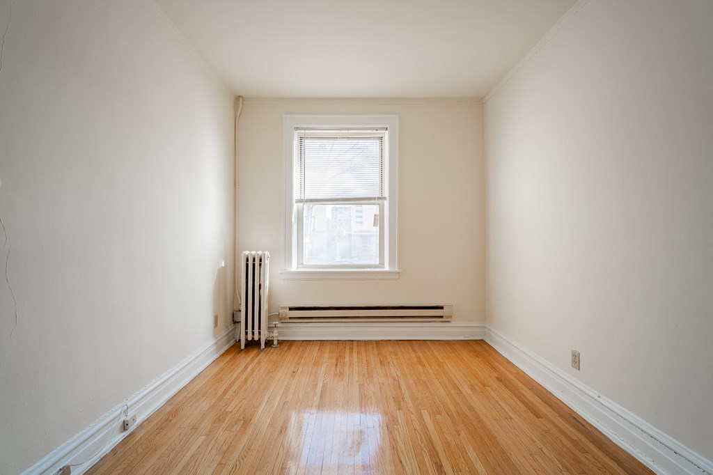 an empty room with wooden floors and a window