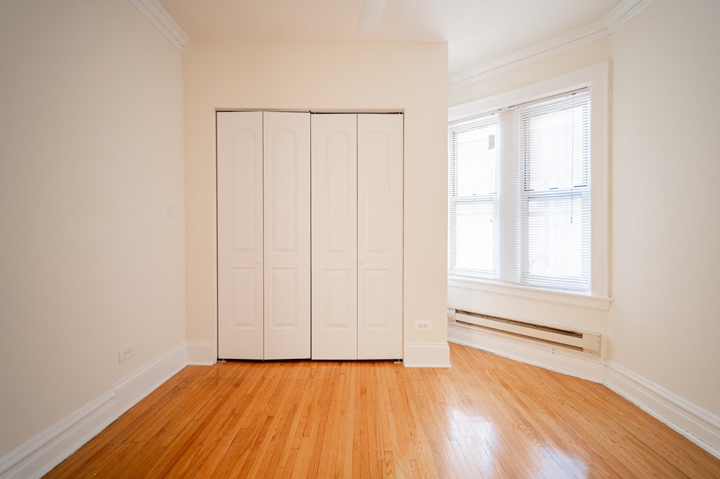an empty room with a wooden floor and a white closet