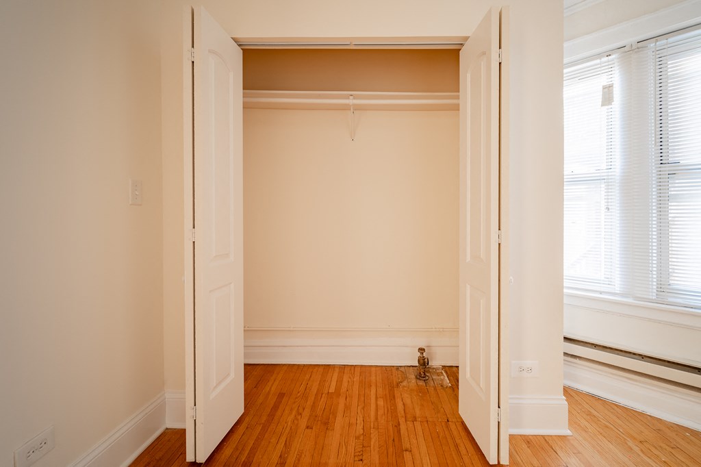an empty room with wooden floors and white walls