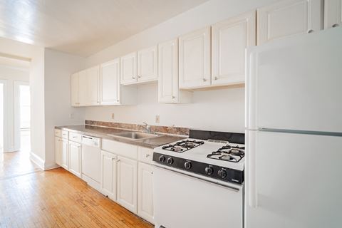 a kitchen with white cabinets and a stove and refrigerator