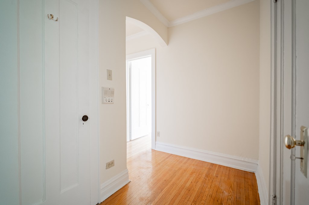 an empty room with white walls and a wood floor