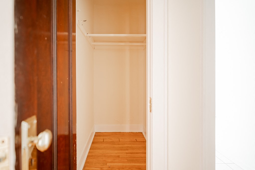 a room with a wooden floor and white walls and a wooden door
