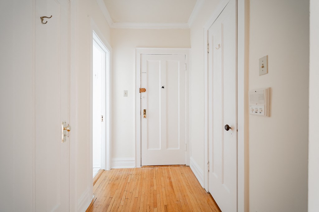a hallway with white doors and a wood floor