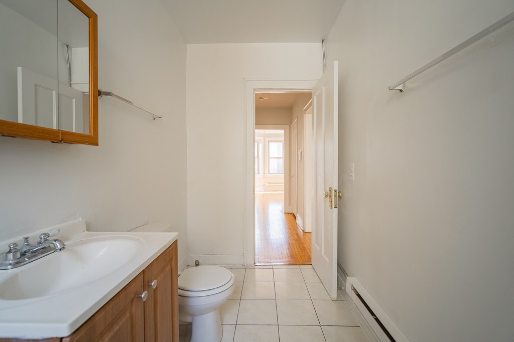 a bathroom with a sink and a toilet and a door to a hallway