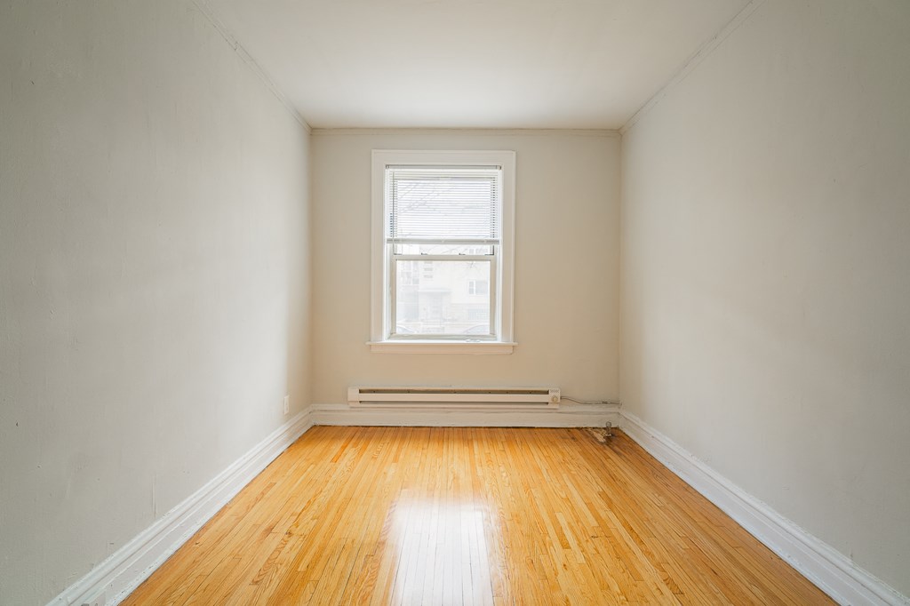 an empty room with wooden floors and a window