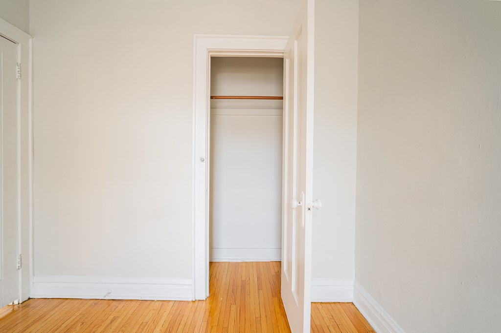an empty room with a closet and a wooden floor