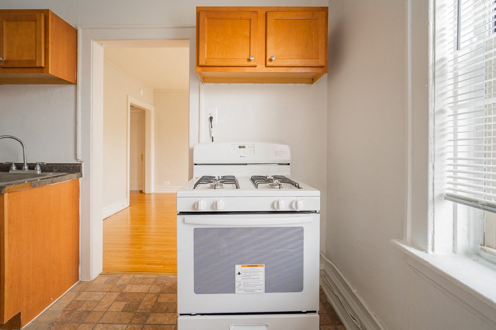 an empty kitchen with a stove and a window