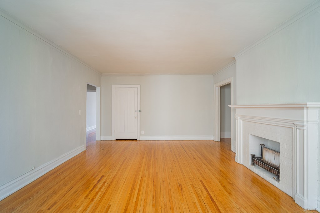 a living room with a fireplace and wooden floors