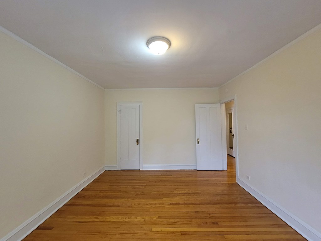 a living room with wood floors and white walls and a white door
