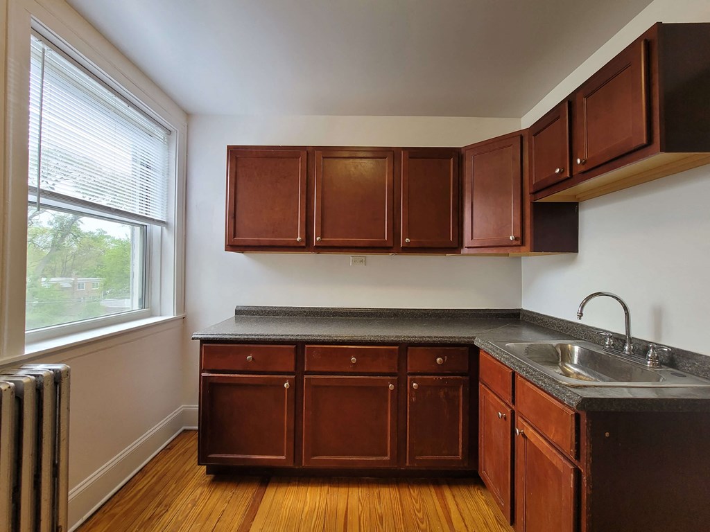 a kitchen with wooden cabinets and a sink and a window