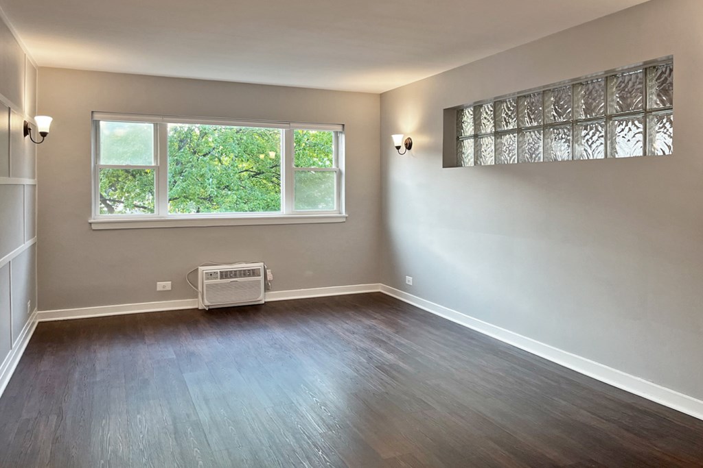A room with a window and a wall-mounted air conditioner unit.