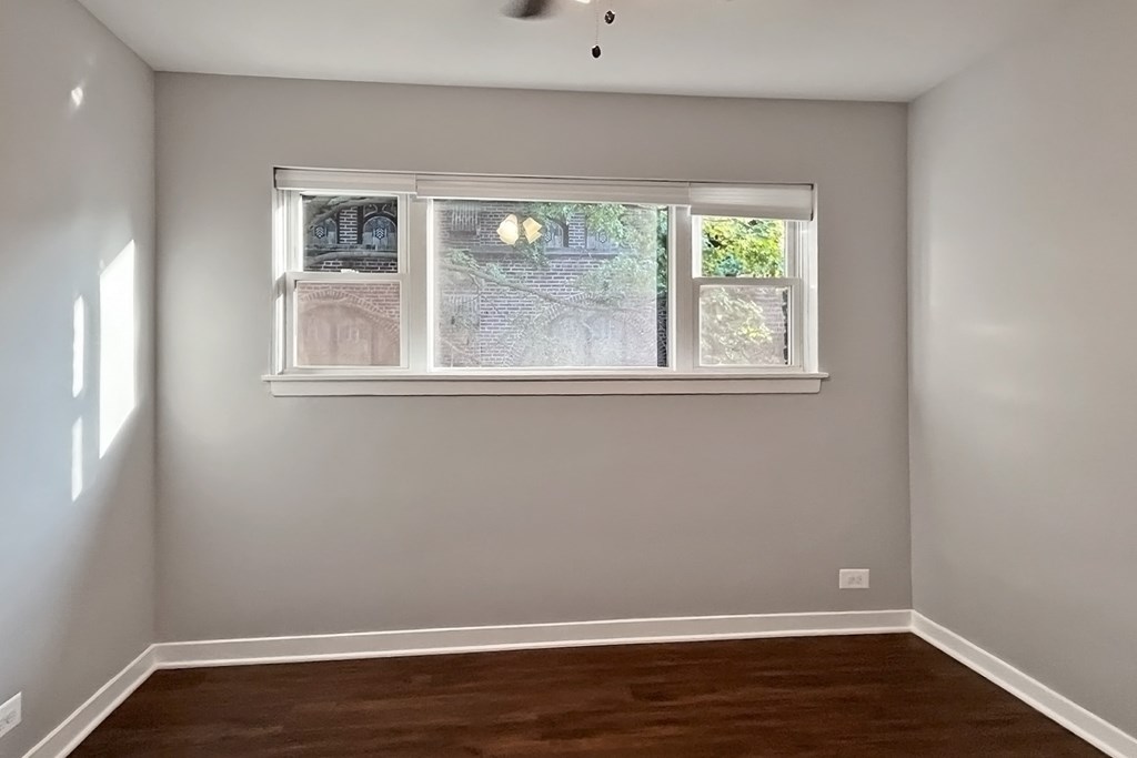 A room with a window and a ceiling fan.