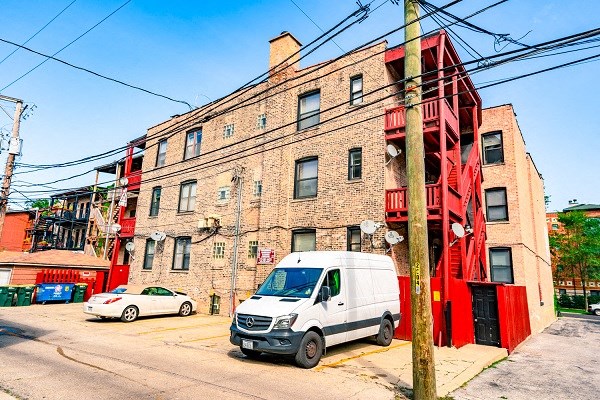 a white van parked in front of a brick building