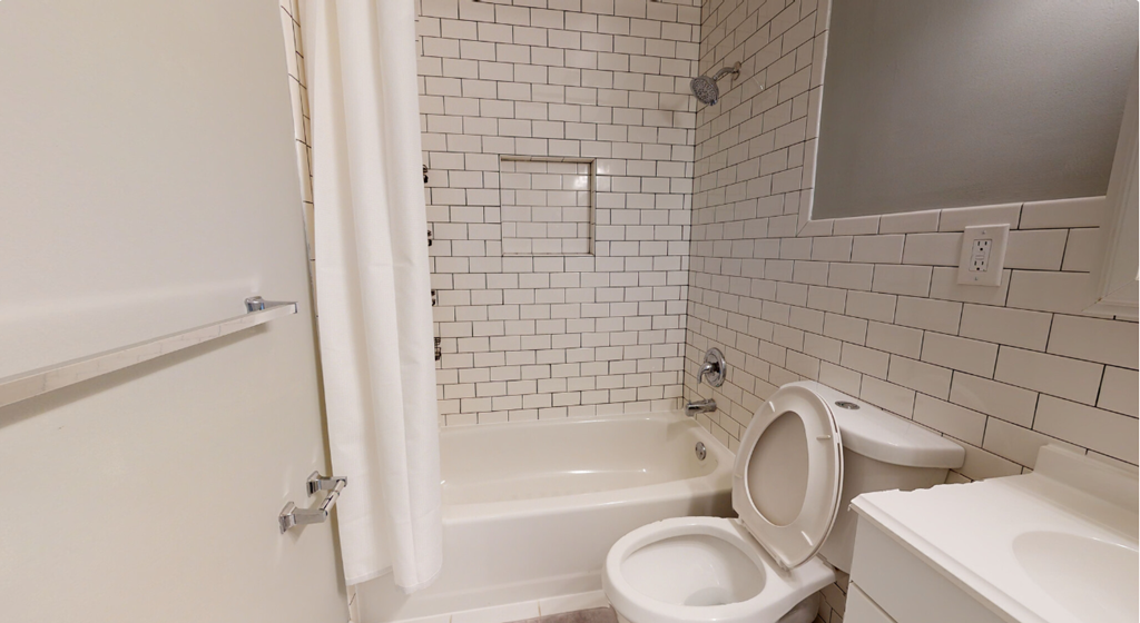a bathroom with a toilet and a tub and a sink