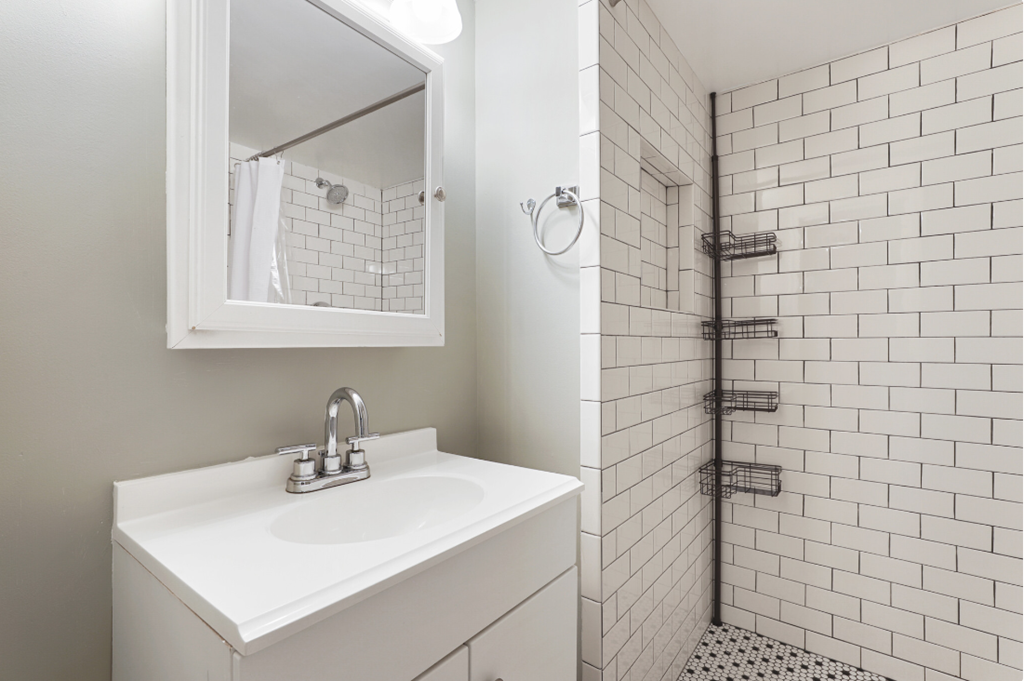 a white bathroom with a sink and a shower