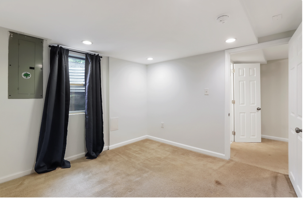 an empty room with a window and a curtain