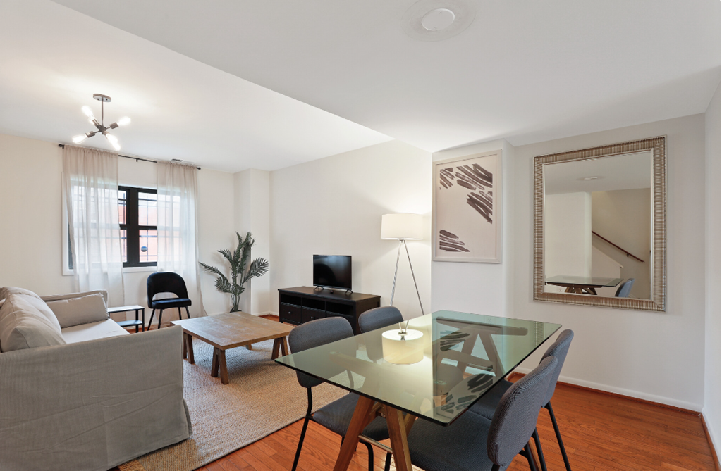a living room with a glass dining table and a couch