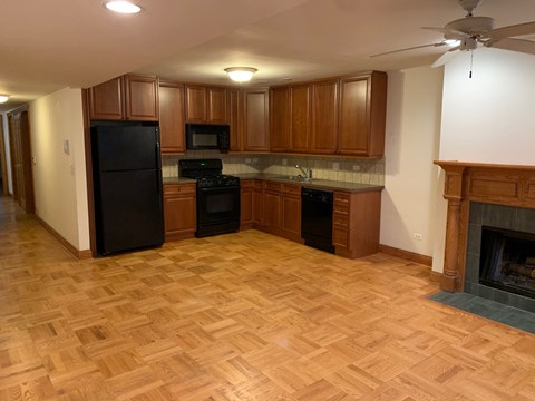 a kitchen with wood flooring and a fireplace