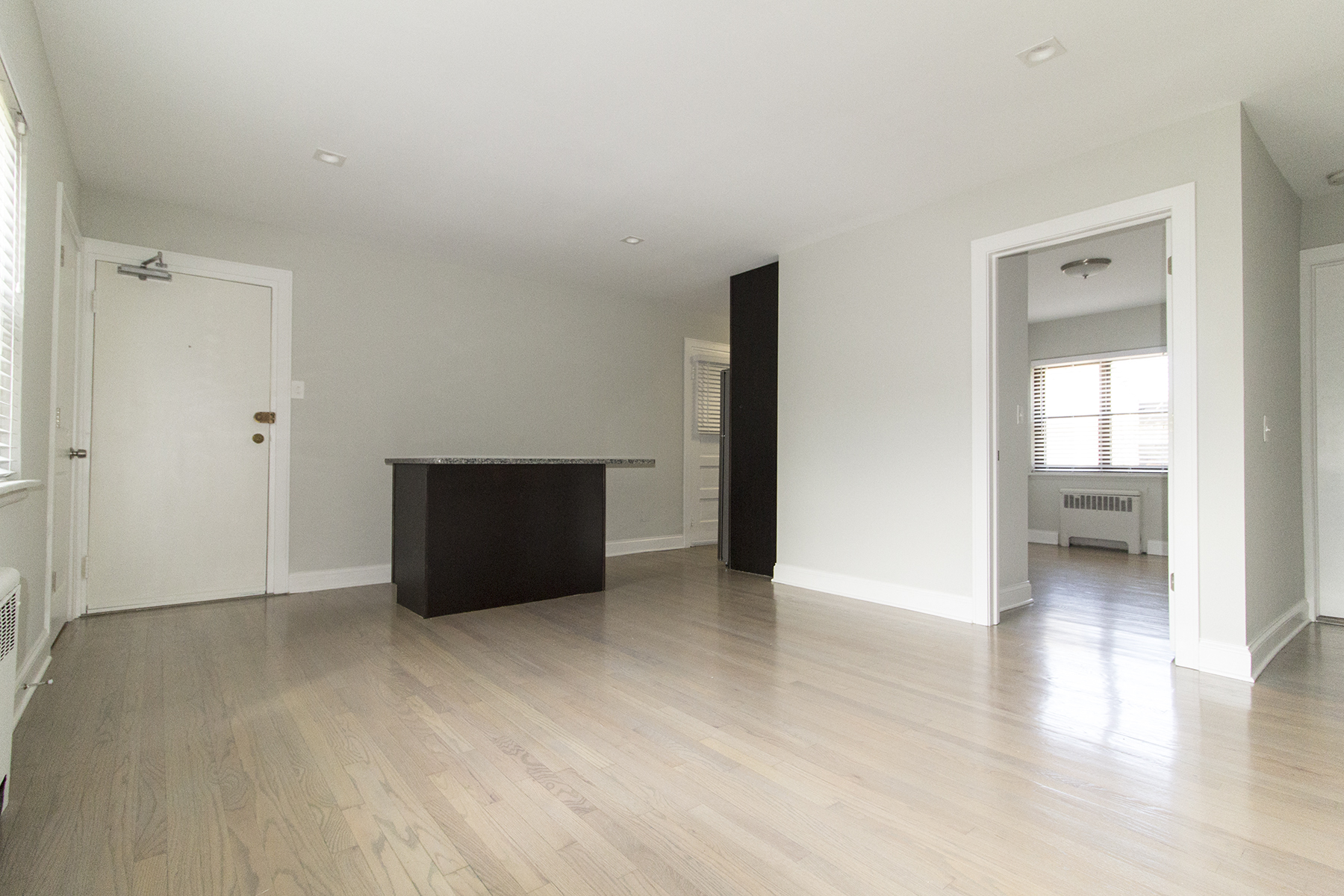 an empty living room with white walls and wooden floors