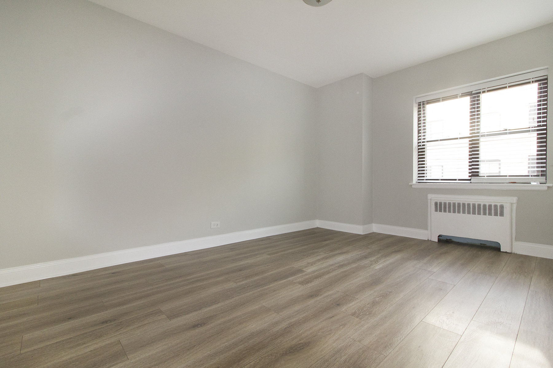 an empty room with wood floors and a window