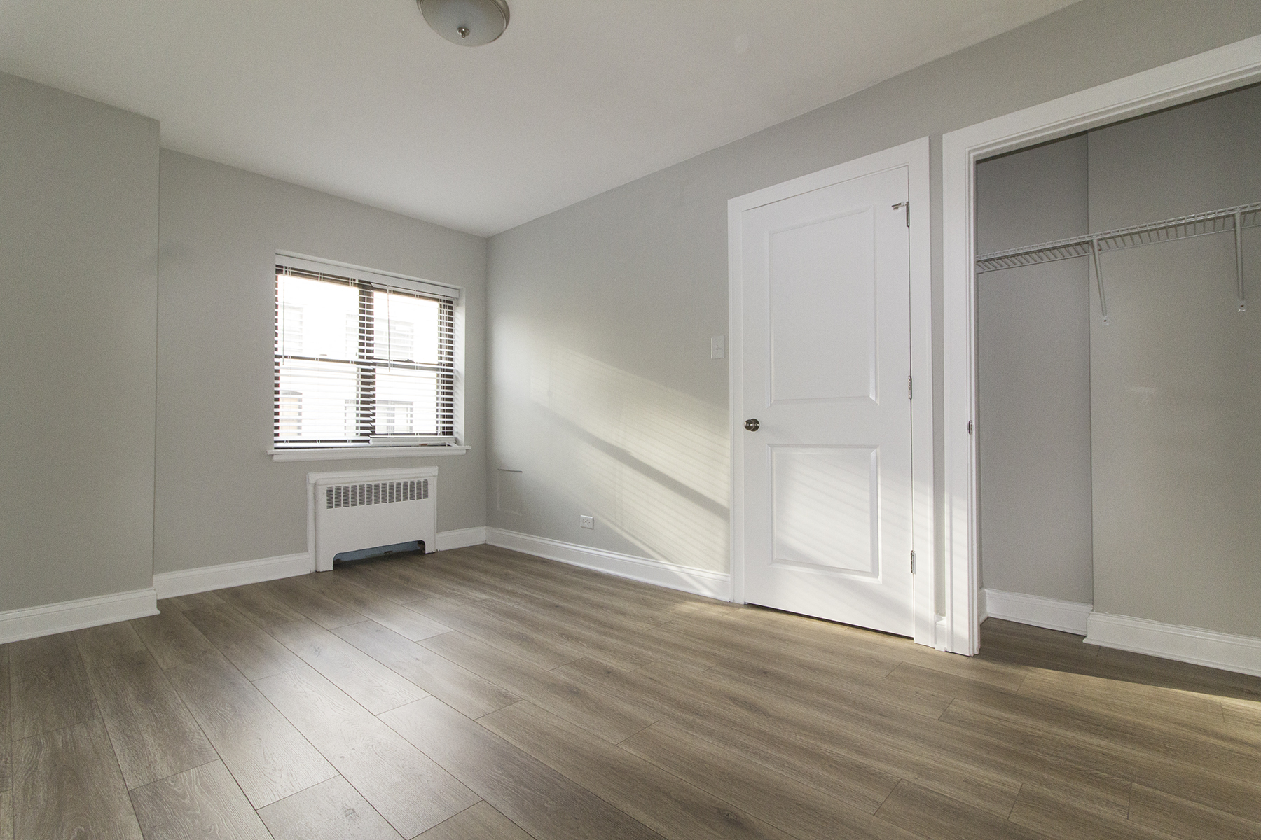 an empty living room with a door to a closet and a window
