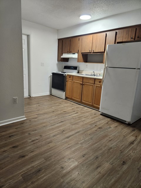 A kitchen with wooden cabinets and a white refrigerator.