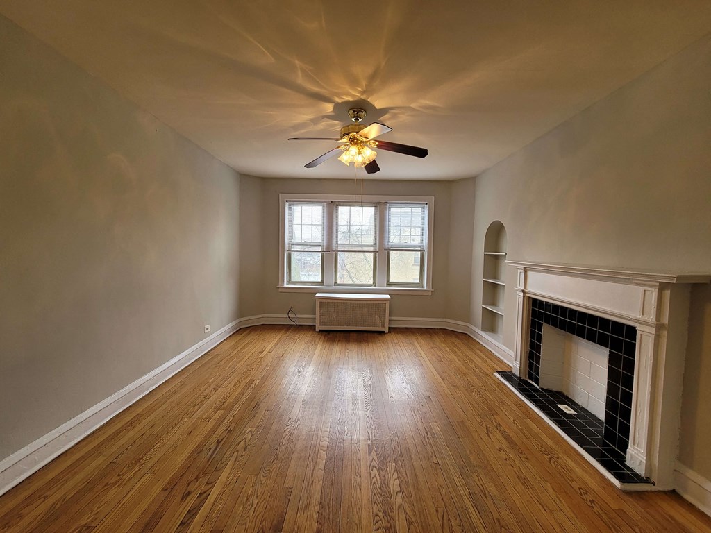 a living room with a fireplace and a ceiling fan