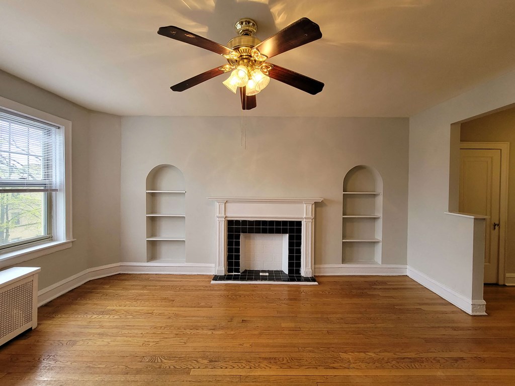 a living room with a fireplace and a ceiling fan