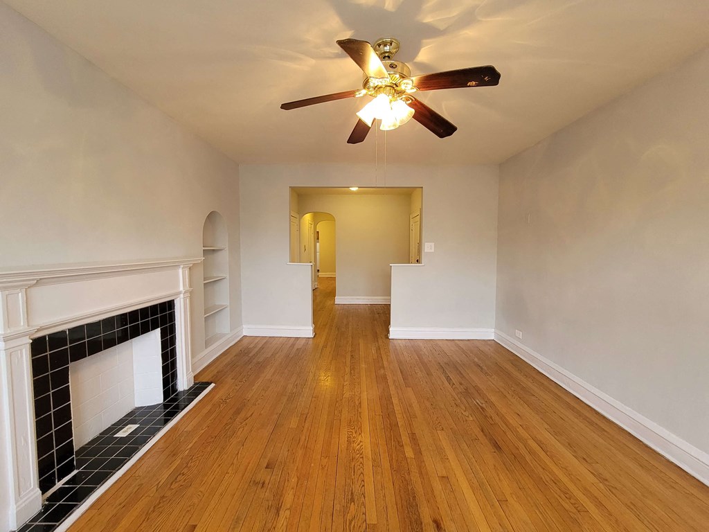 a living room with a fireplace and a ceiling fan