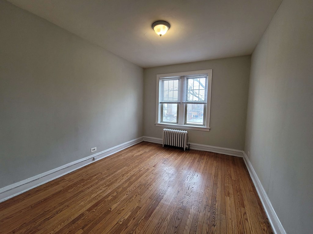 a empty living room with wood floors and a window