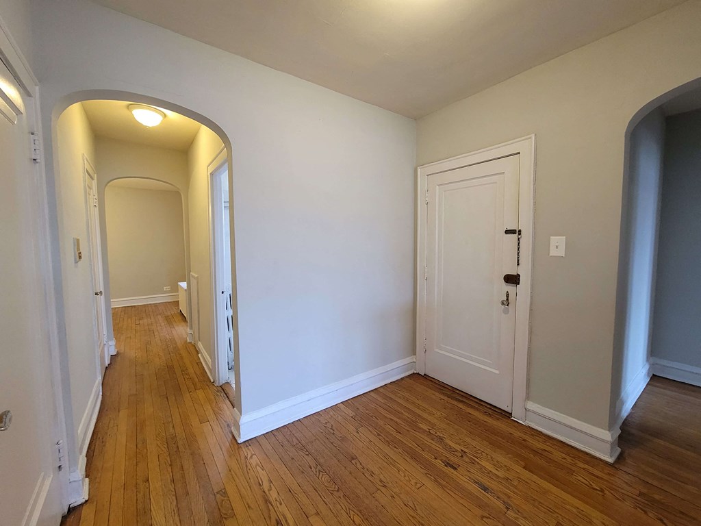 a living room and hallway with wood floors and white walls