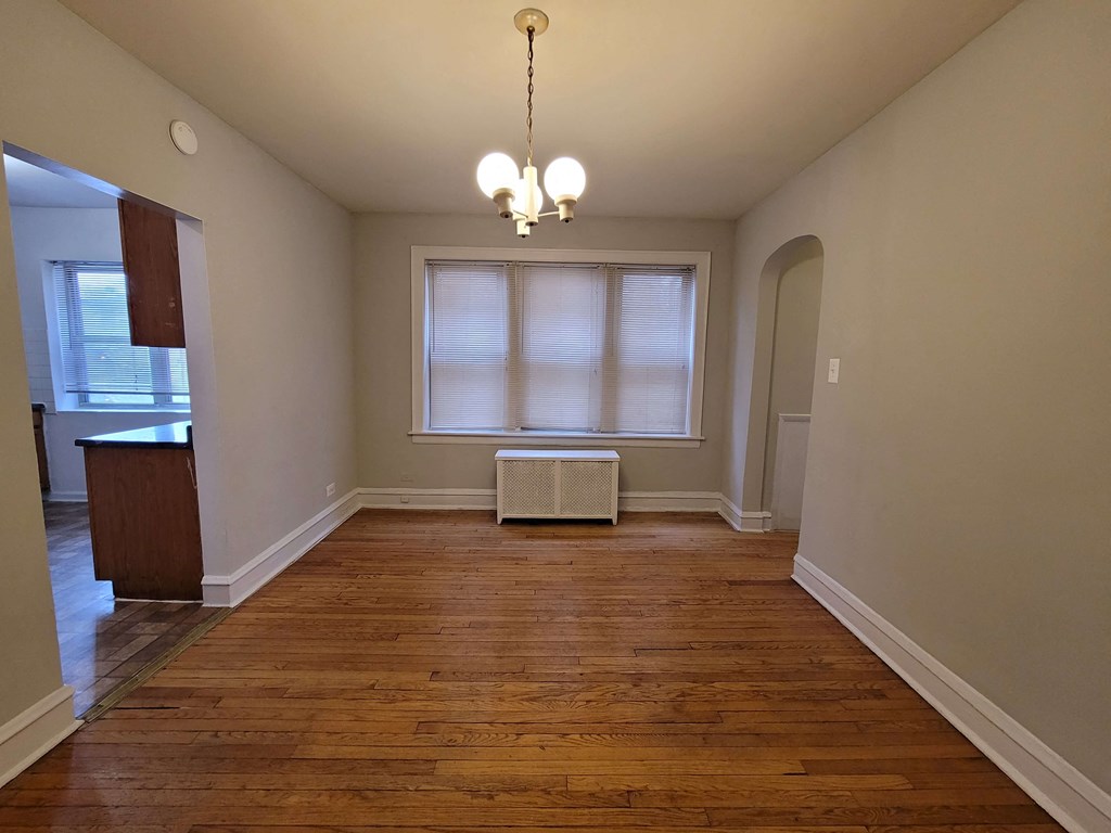 a empty living room with a window and a radiator