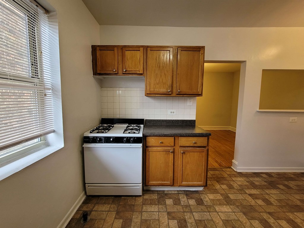 an empty kitchen with a stove and cabinets