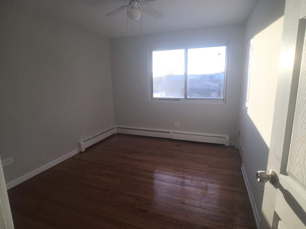 an empty room with wooden floors and a window