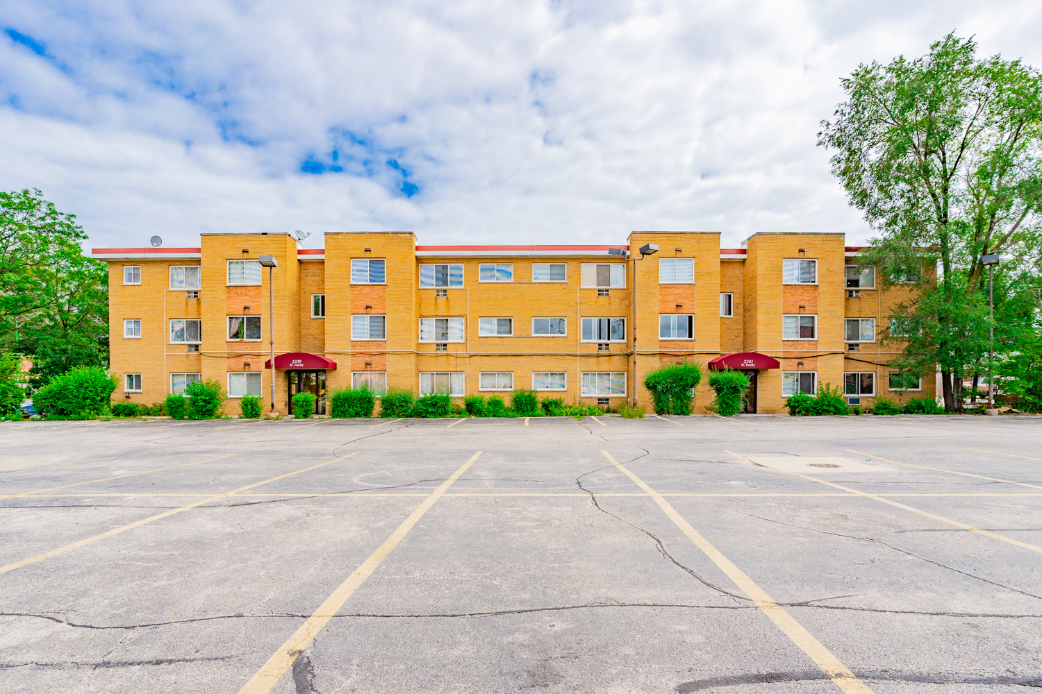 an empty parking lot in front of an apartment building