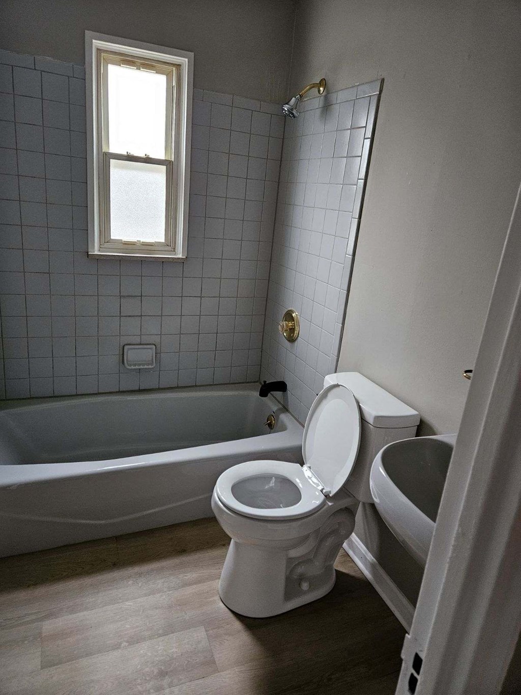 a bathroom with a toilet and a tub and a sink