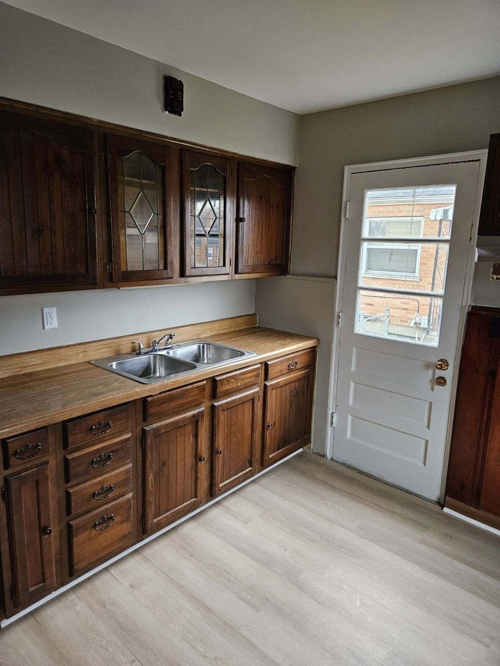 an empty kitchen with wooden cabinets and a sink