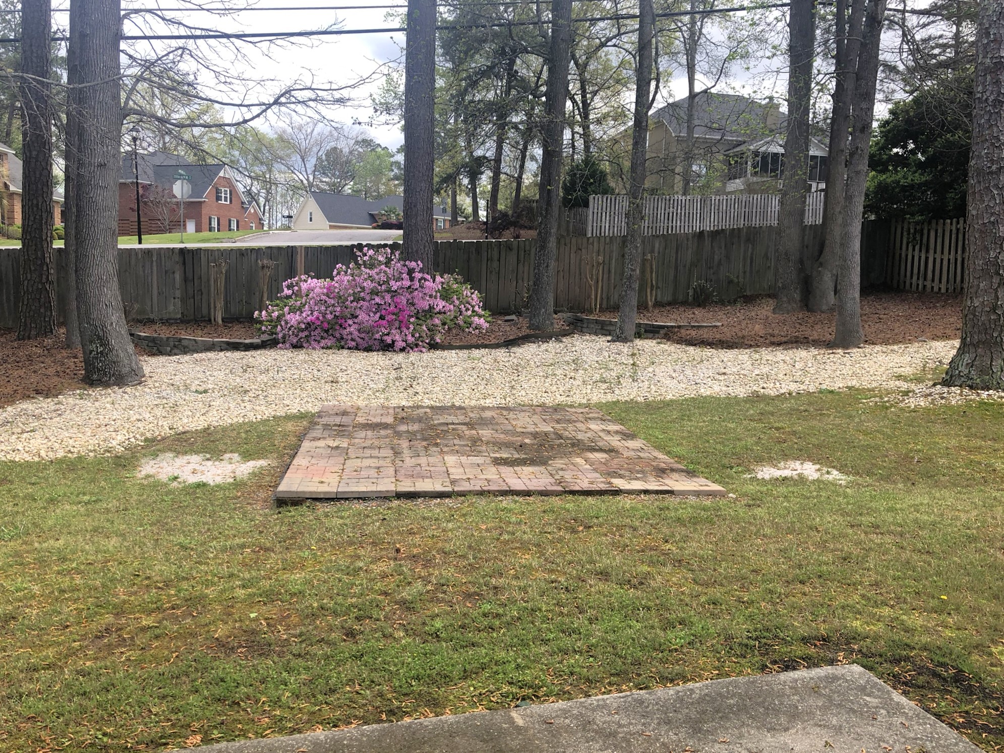 a backyard with a wooden platform in the grass