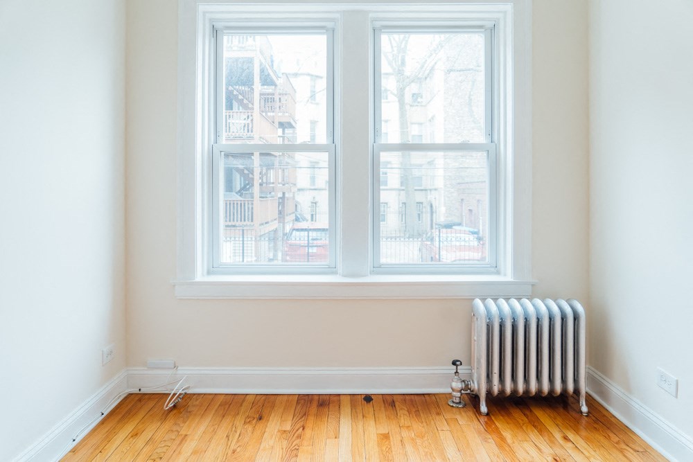 a room with a radiator and three windows